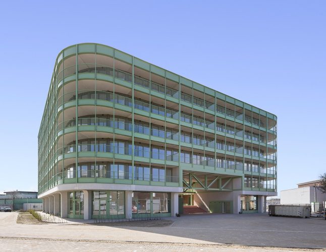 Image for A bright industrial building made from pale-green steel and glass